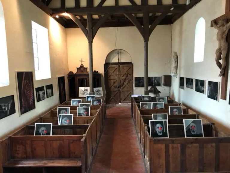 Exposition Vanités et Carcasses d'Ismaël Maurey : dessins de crânes au nez rouge posés sur les bancs de la chapelle Notre-Dame d'Épinay, 2018