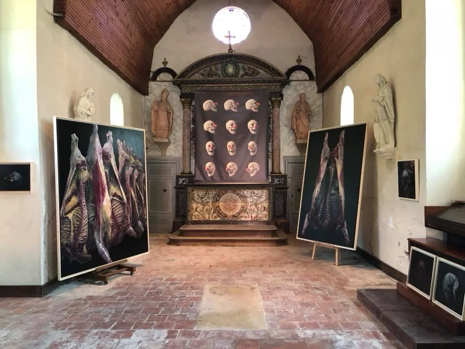 Chœur de la chapelle Notre-Dame d'Épinay : bâche de crânes au nez rouge devant l'autel, encadrée de grands formats de carcasses, Ismaël Maurey 2018